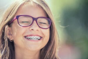 Young girl with braces and glasses smiling